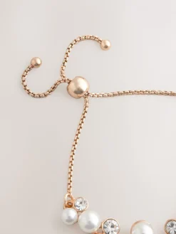 Goudkleurig - Doorgetrokken armband met pareleffect en glitters*Next