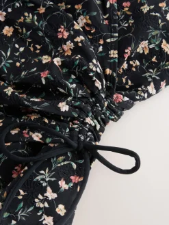 Zwart met broderie en fijne print - Badpak met vormgevende zijrimpeling en buikcorrectie*Next Clearance