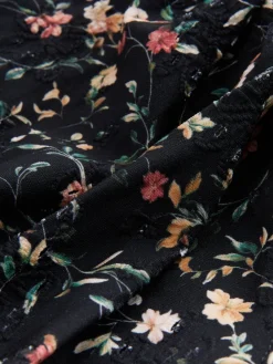 Zwart met broderie en fijne print - Badpak met vormgevende zijrimpeling en buikcorrectie*Next Clearance